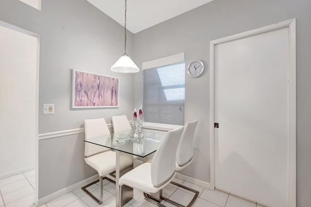 dining space with light tile patterned flooring and vaulted ceiling