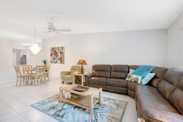 tiled living room with ceiling fan with notable chandelier and vaulted ceiling