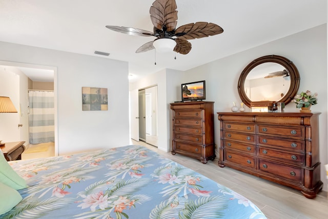 bedroom featuring ceiling fan, ensuite bathroom, a closet, and light wood-type flooring