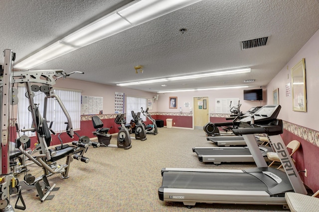 workout area with carpet floors and a textured ceiling