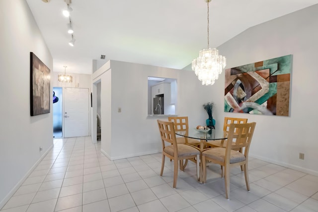 dining space featuring an inviting chandelier, rail lighting, vaulted ceiling, and light tile patterned floors