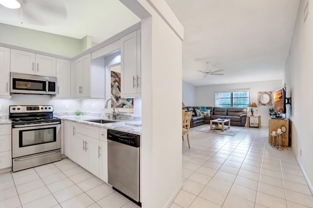 kitchen featuring sink, ceiling fan, white cabinetry, stainless steel appliances, and light tile patterned flooring