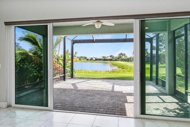 doorway to outside with a water view, ceiling fan, and a healthy amount of sunlight