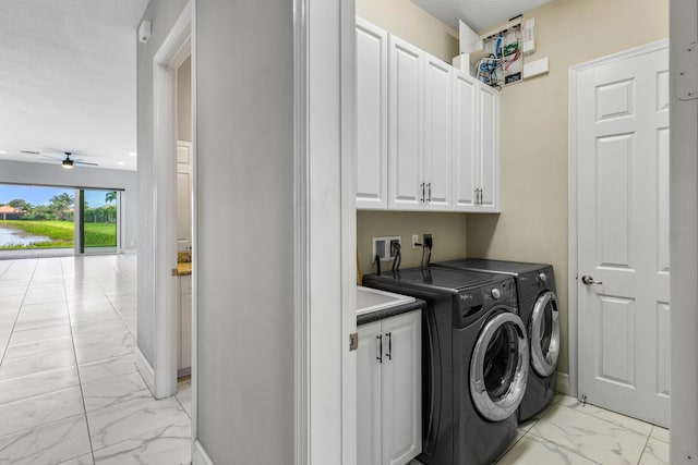 laundry area featuring ceiling fan, cabinets, and washing machine and clothes dryer