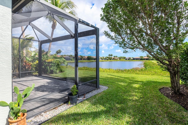 view of yard featuring a patio, a water view, and a lanai