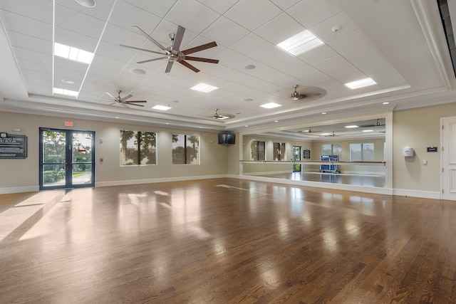 workout room featuring ceiling fan, a tray ceiling, and hardwood / wood-style floors