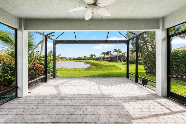 unfurnished sunroom with a water view and ceiling fan