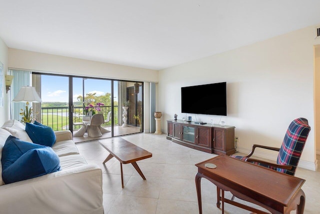 living room featuring light tile patterned floors, visible vents, and baseboards