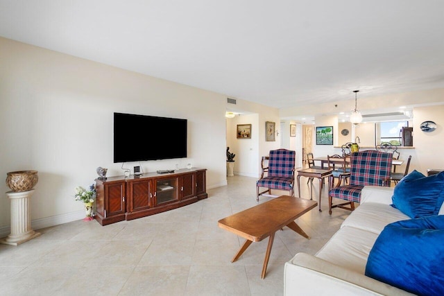 living room featuring baseboards, visible vents, and light tile patterned flooring