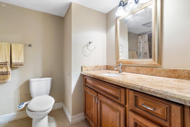 bathroom featuring baseboards, vanity, and toilet