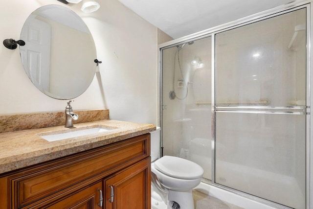 bathroom with a stall shower, vanity, and toilet