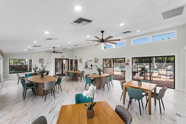 dining area featuring marble finish floor, plenty of natural light, and visible vents