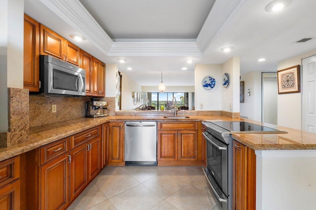 kitchen with stainless steel appliances, a raised ceiling, visible vents, brown cabinetry, and a peninsula