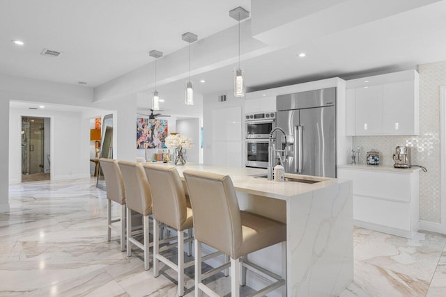 kitchen featuring visible vents, modern cabinets, marble finish floor, white cabinetry, and appliances with stainless steel finishes
