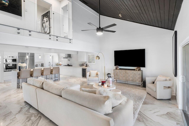 living room with wood ceiling, high vaulted ceiling, marble finish floor, and ceiling fan