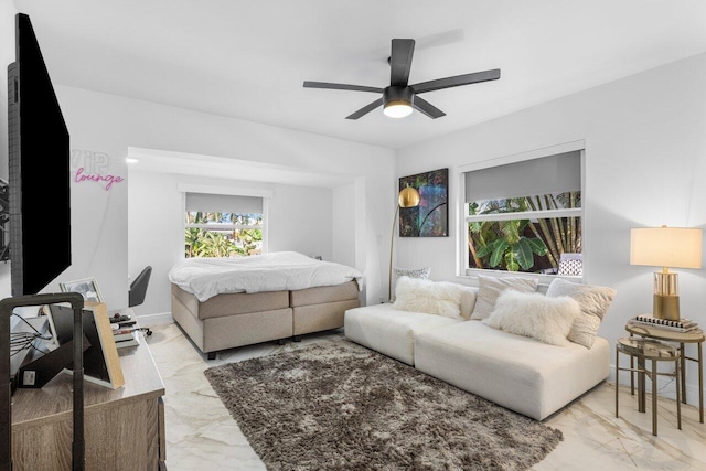 bedroom with a ceiling fan, baseboards, and marble finish floor
