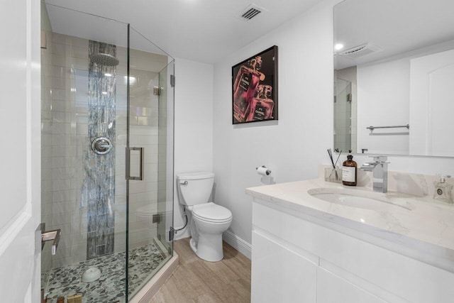 bathroom featuring visible vents, a shower stall, toilet, and wood finished floors