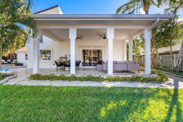 back of house with fence, stucco siding, a patio, outdoor lounge area, and a ceiling fan