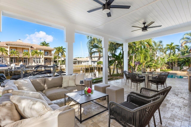 view of patio / terrace with a boat dock, an outdoor living space, an outdoor pool, outdoor dining area, and ceiling fan
