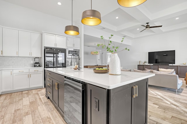 kitchen featuring wine cooler, sink, a center island with sink, hanging light fixtures, and white cabinets