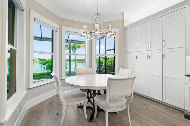 dining space with baseboards, an inviting chandelier, light wood-style flooring, and crown molding