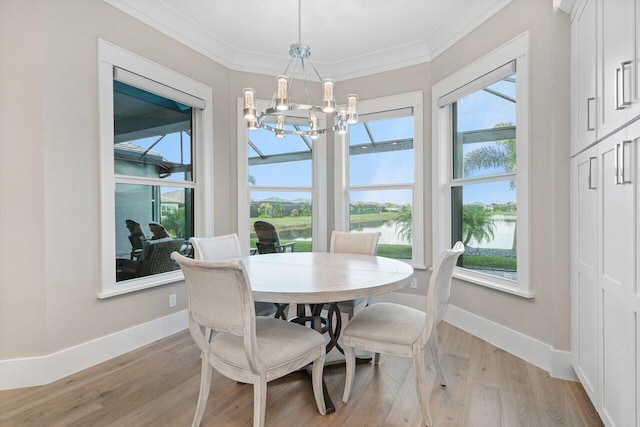 dining area featuring light wood-style flooring, a chandelier, and ornamental molding