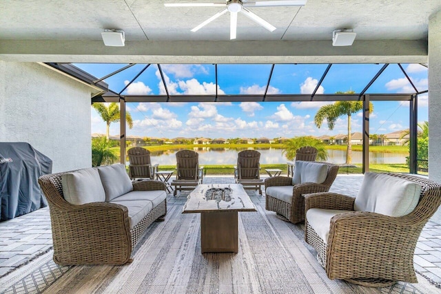 view of patio with a lanai, grilling area, an outdoor living space with a fire pit, and a water view