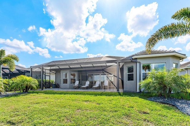 rear view of house featuring a patio, a yard, a lanai, and stucco siding