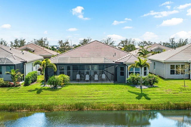 back of property featuring stucco siding, a water view, a lanai, a tiled roof, and a lawn