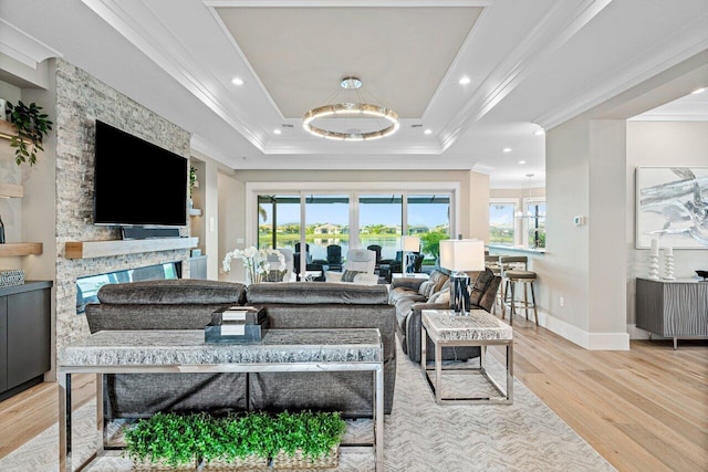 living area with recessed lighting, a raised ceiling, wood finished floors, and ornamental molding