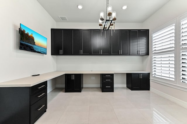 unfurnished office featuring recessed lighting, visible vents, baseboards, built in desk, and an inviting chandelier