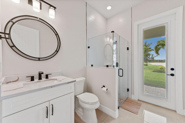 bathroom featuring toilet, a stall shower, vanity, and tile patterned floors