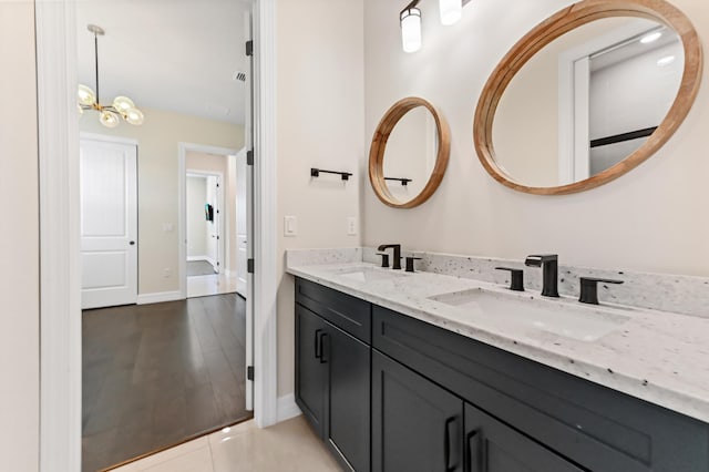 full bathroom with tile patterned floors, a sink, baseboards, and double vanity