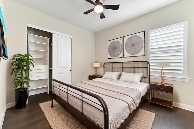 bedroom with ceiling fan, dark wood-style flooring, a closet, and baseboards