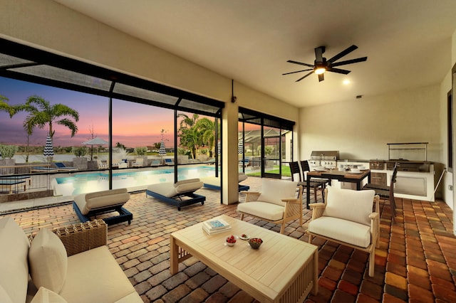 view of patio / terrace featuring a ceiling fan, a lanai, an outdoor kitchen, and a community pool