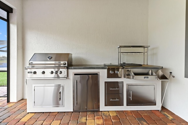 view of patio featuring exterior kitchen and a grill