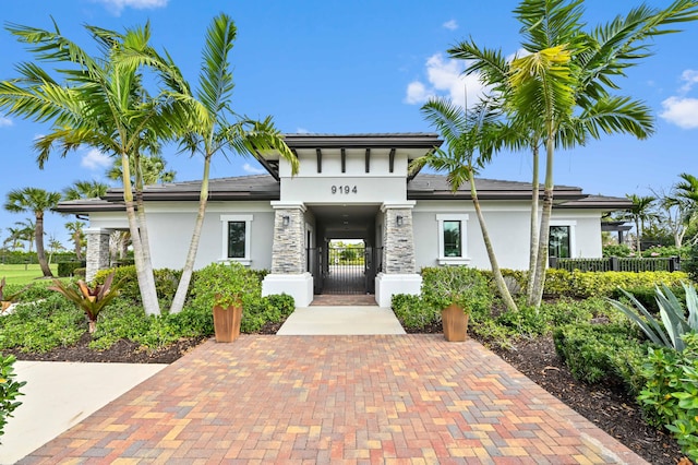 view of front of house featuring a gate, fence, and stucco siding