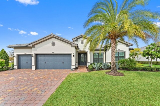 mediterranean / spanish house with an attached garage, a front lawn, decorative driveway, and stucco siding