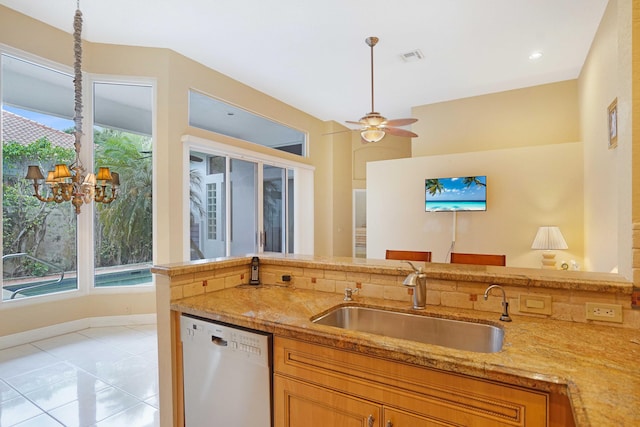 kitchen featuring light tile patterned floors, light stone counters, a sink, dishwasher, and pendant lighting