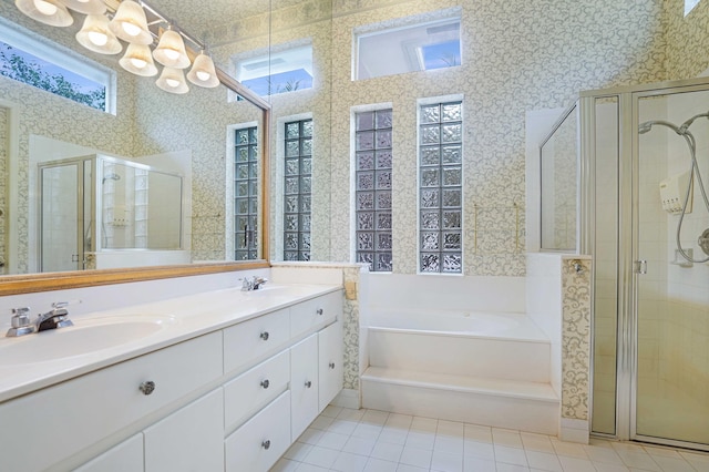 bathroom with a garden tub, a sink, a wealth of natural light, and wallpapered walls