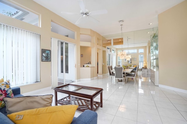 living area featuring light tile patterned flooring, ceiling fan, visible vents, and baseboards