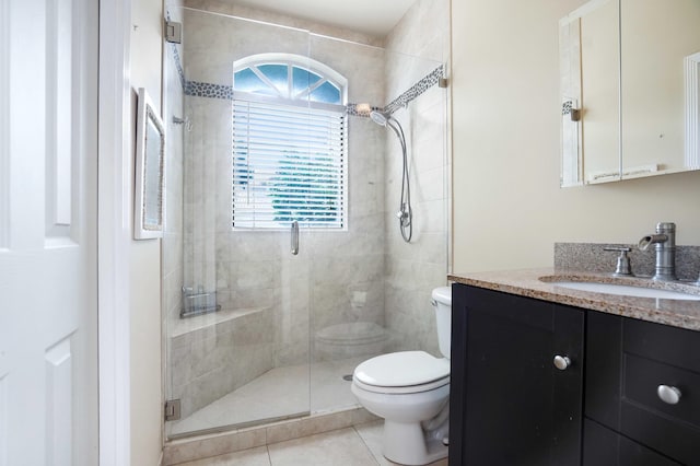 bathroom featuring toilet, a shower stall, vanity, and tile patterned floors