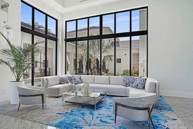 living room with a towering ceiling and baseboards