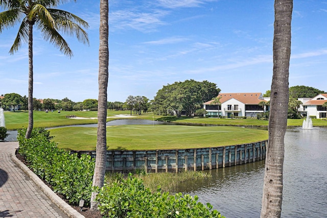 view of home's community featuring a water view, view of golf course, and a yard