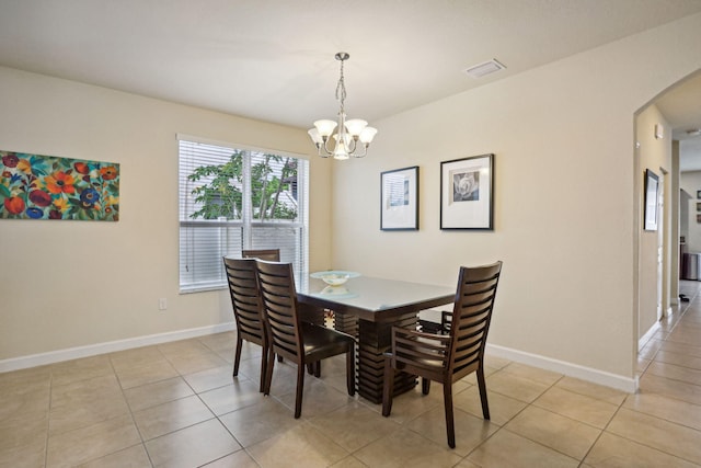 tiled dining space featuring a chandelier