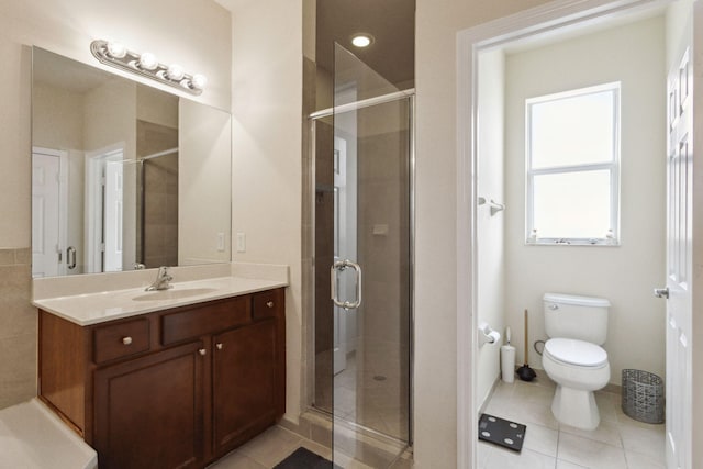 bathroom featuring toilet, vanity, tile patterned floors, and a shower with shower door