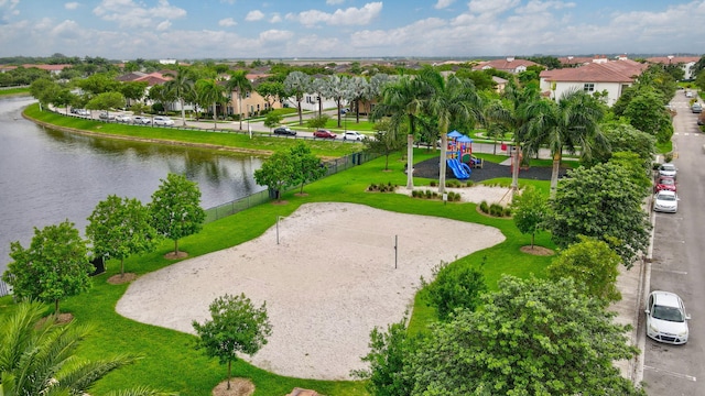 surrounding community with a water view, a playground, and volleyball court