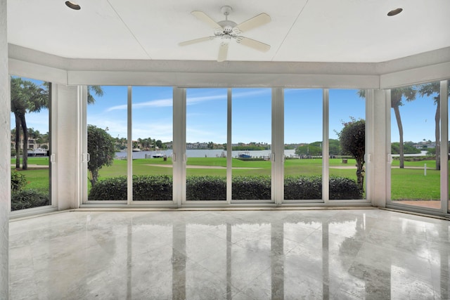 unfurnished sunroom with a water view and ceiling fan