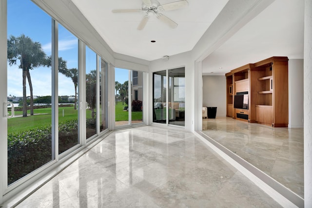 unfurnished sunroom featuring ceiling fan