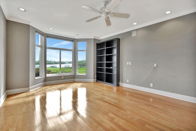 empty room with crown molding, ceiling fan, and light wood-type flooring